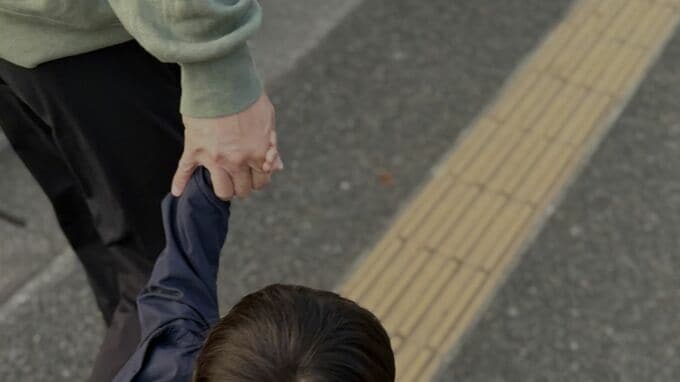 手をつないで歩く親子の手元