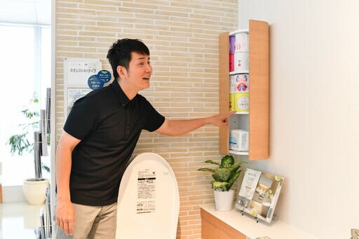 トイレットペーパーが入っている収納部と男性