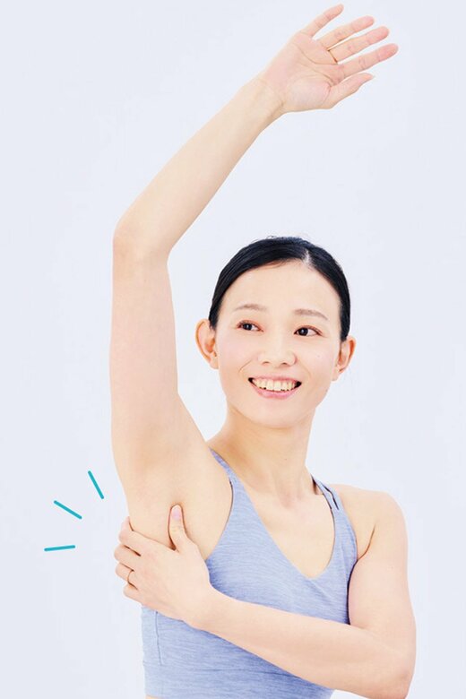 腕を上げ、脇あたりをつまむ女性