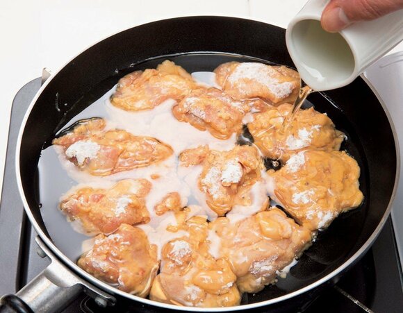 フライパンに並べ入れ、鶏肉が半分強浸るまでサラダ油を注ぐ