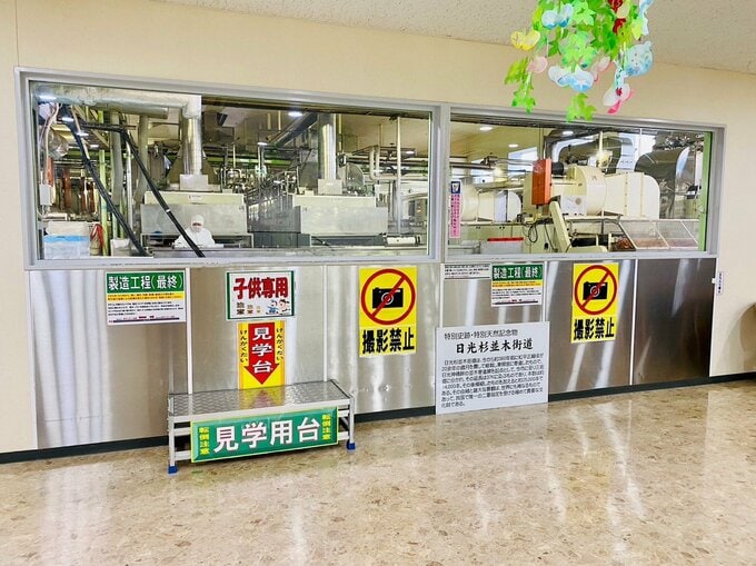 窓越しに見られるリニアモーター式のコンベアと製造現場