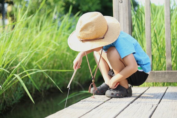 ザリガニを探す小学生