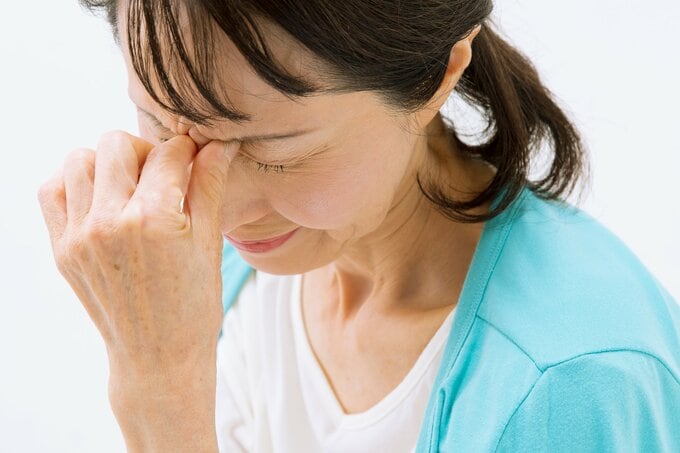 目頭を押さえる女性