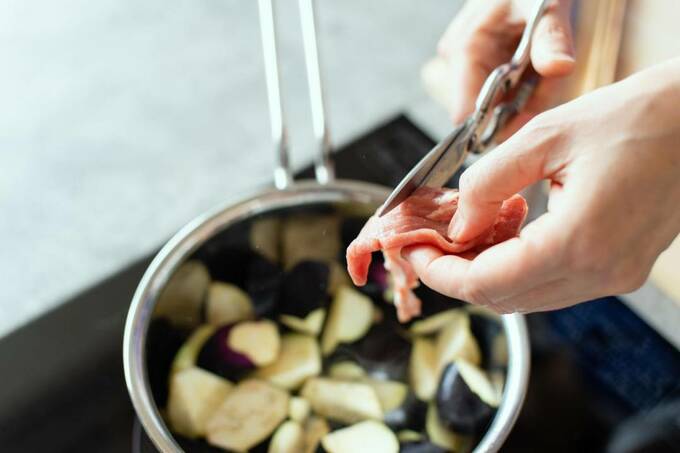 キッチンバサミを使って肉を切る様子
