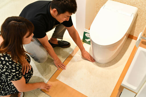 トイレの床を見る夫婦