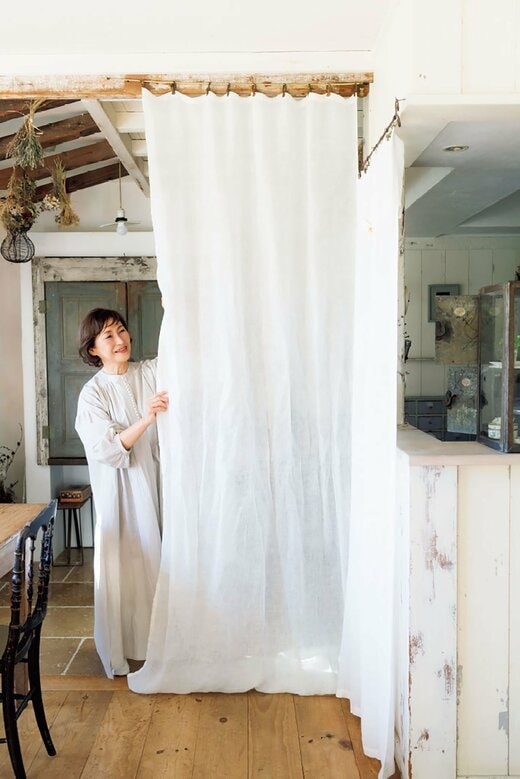 カーテンを引く女性