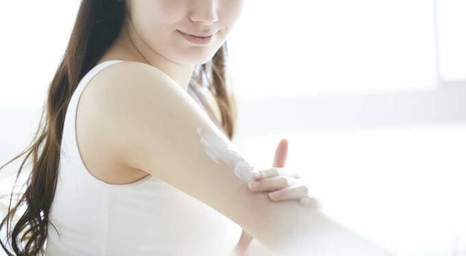 腕に塗り込む女性