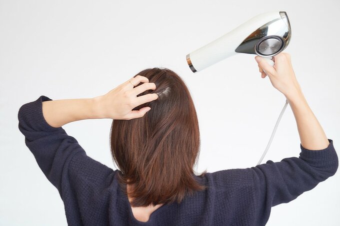 ドライヤーをする女性