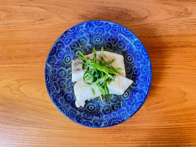 ヒラメの蒸しもの。仕上げに青ネギをあしらい、熱したごま油をネギに目がけて少しかける。お好みでお醤油を