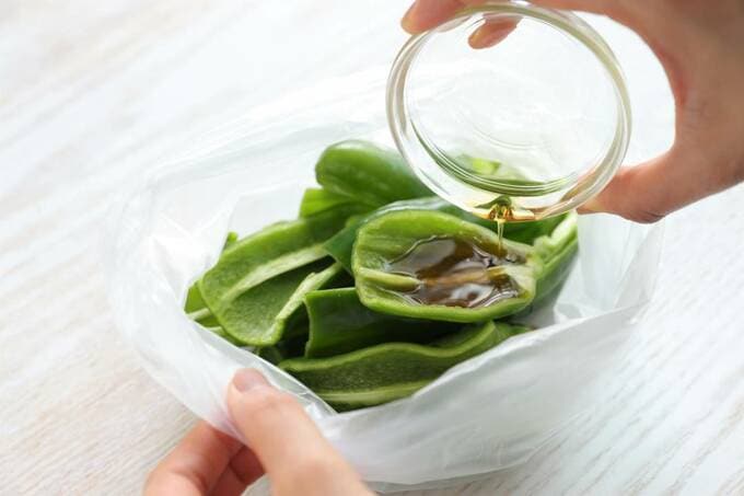 袋に入ったピーマンに調味料を入れる様子