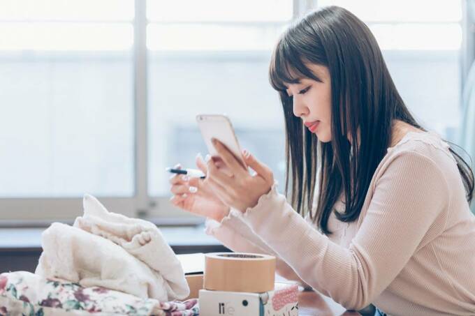 スマホとペンを持つ女性