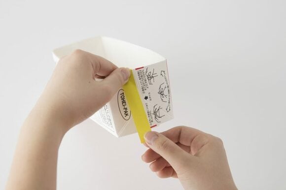 注ぎ口を写真のようにハサミで切って、折り上げましょう