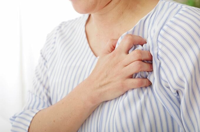 左胸を押さえる女性のイメージ画像