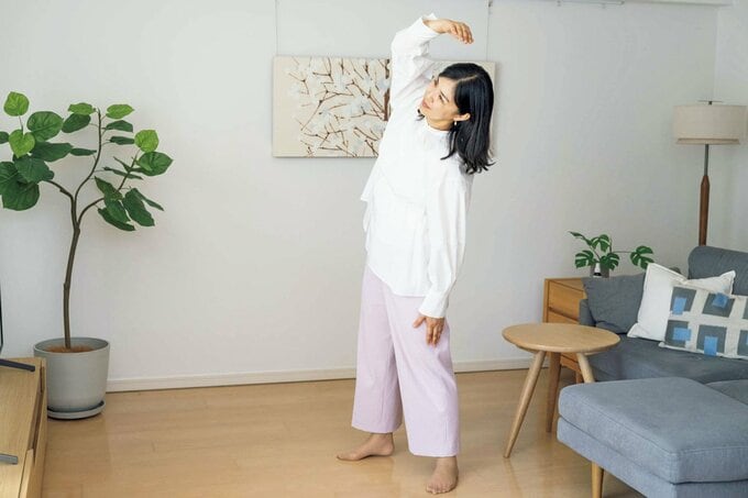 リビングで体操をする女性