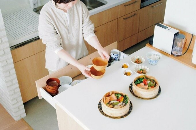 料理が並ぶ台に食器を出す様子