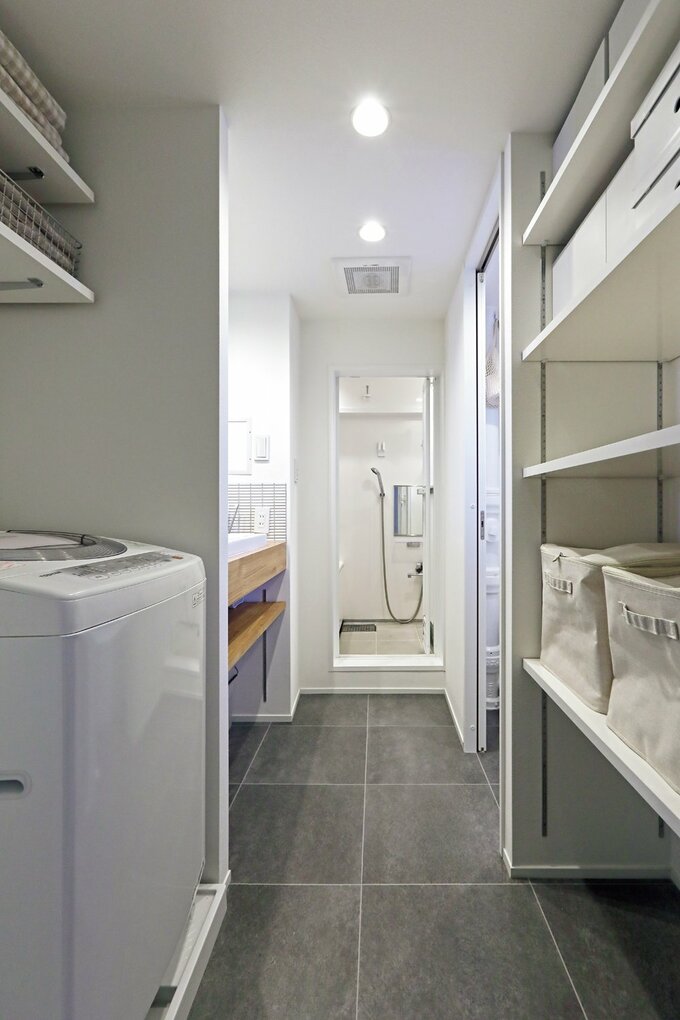 洗面スペースは廊下側に広げ、右側には収納棚を造作