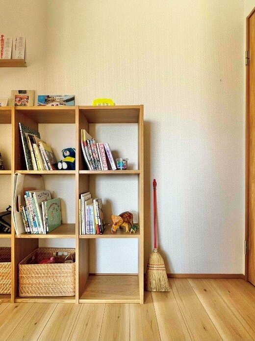 本やおもちゃが置かれた木製シェルフ