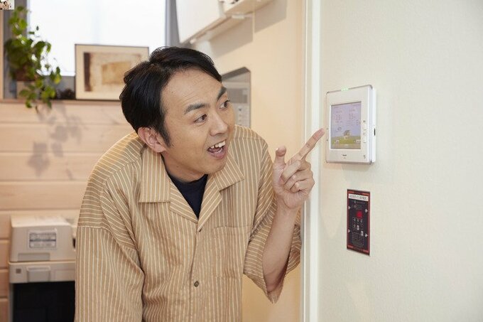 バネルを指差す田中さん