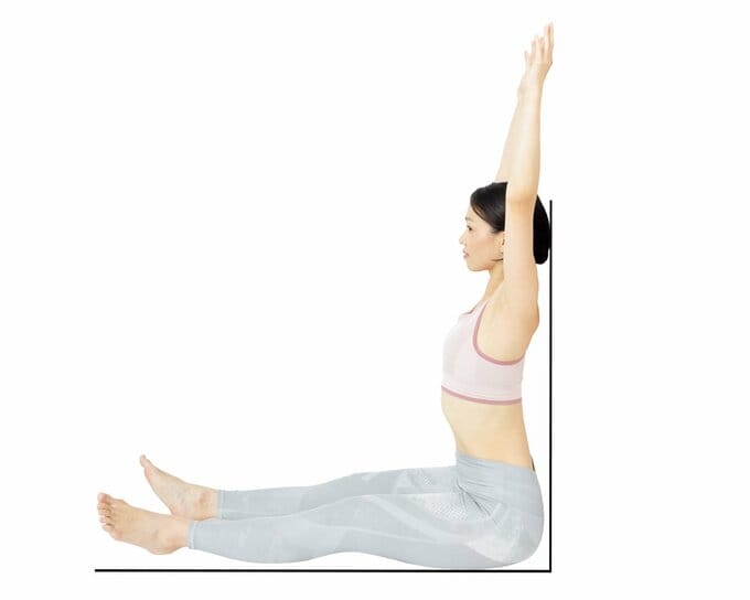 壁に背をつけて脚を伸ばして座り、腕を上げると腰が壁から離れて反っている