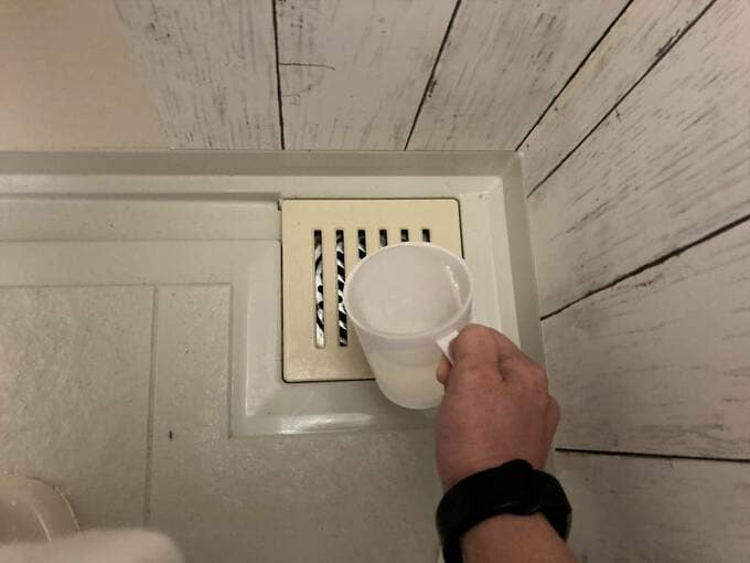 排水口にコップで水を入れる