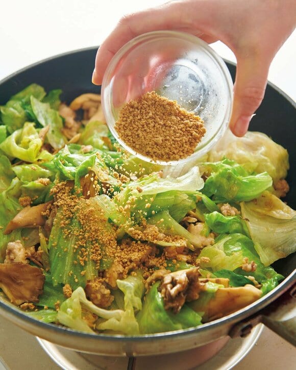 レタス炒めにゴマを加える様子