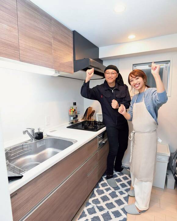 男女がキッチンで手をあげている様子