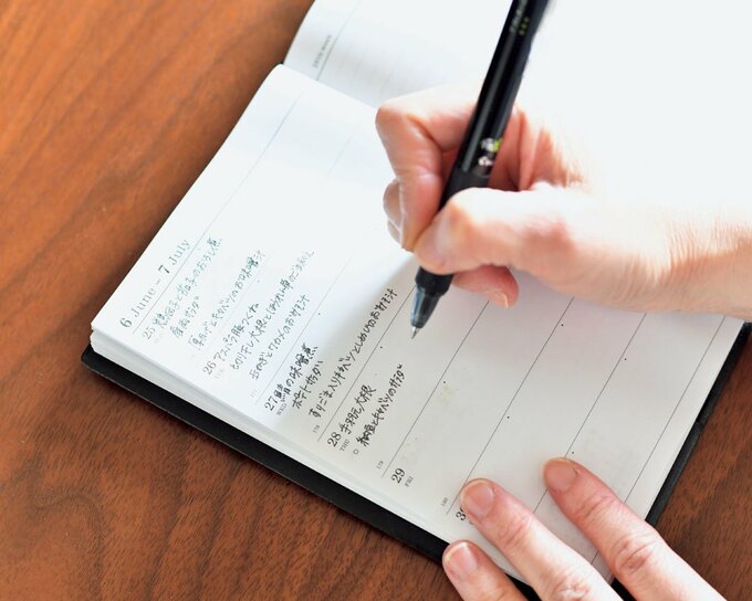 ノートに献立をメモする様子