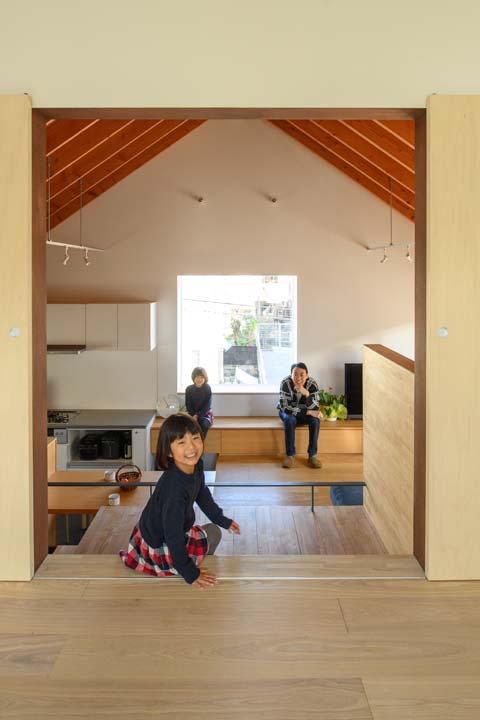 座って談笑する田中さんと妻、子ども