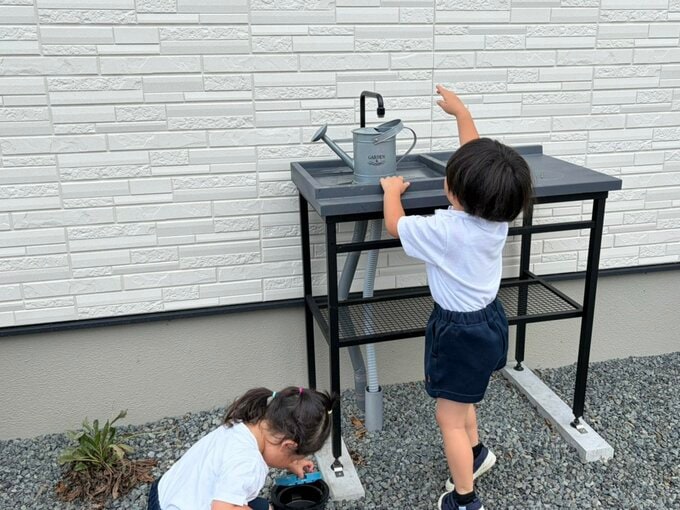 子どもがジョウロに水を入れている様子