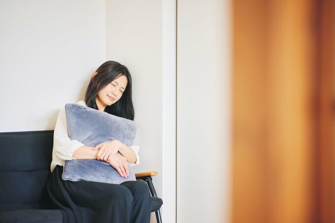 ソファーに座って寝る女性