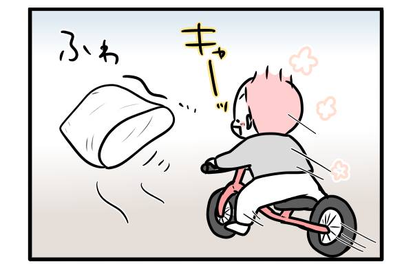 自転車で袋を追いかける子ども