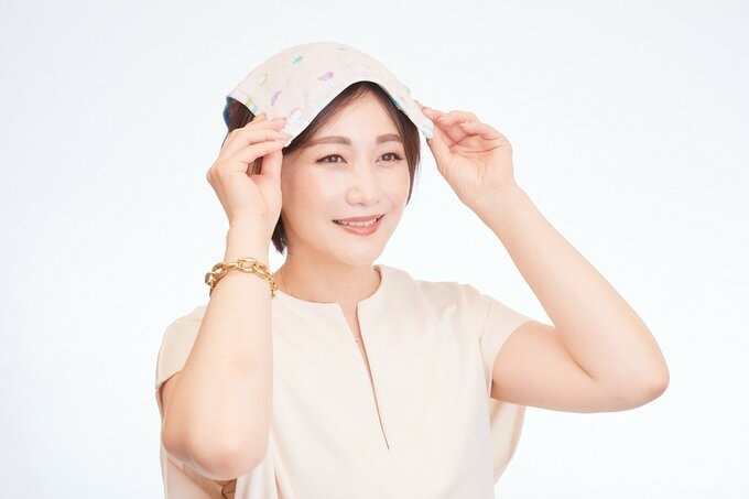 頭にタオルをのせる女性