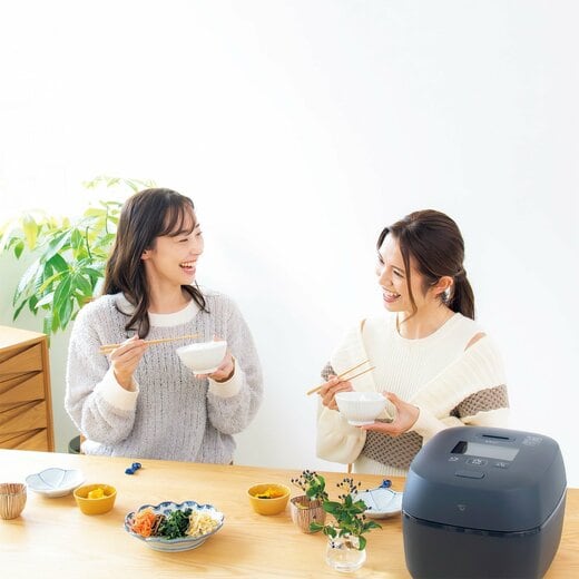 ダイニングテーブルでご飯を食べる二人の女性