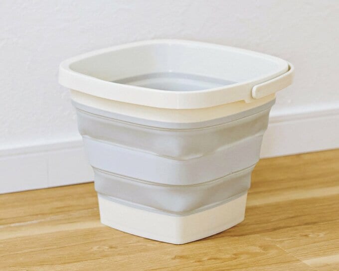 蛇腹がグレーと白の色で交互になっている折りたたみ式のバケツ