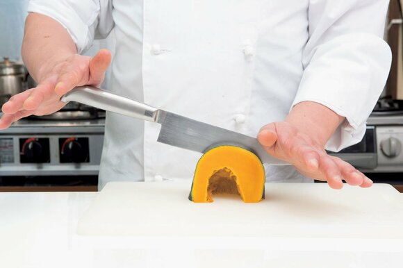 添え手を刃先の峰に当て、そこを支点に包丁の両端を上下にスイングさせながら前方に切り進む