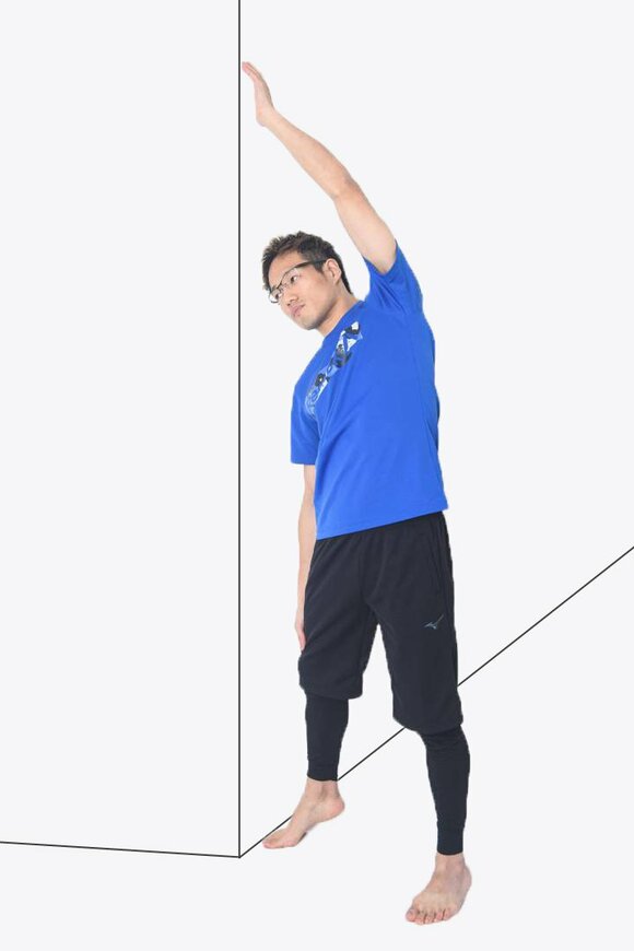 壁の横に立ち手のひらを壁にぴったりつける