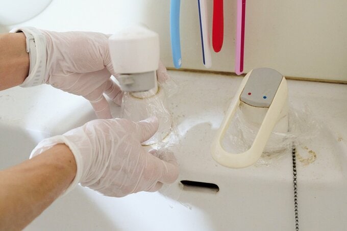 蛇口周りの掃除をするハウスキーパー