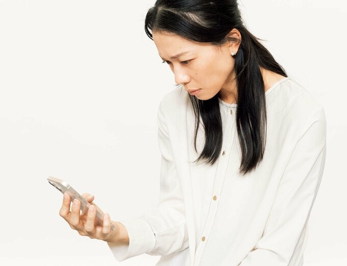 猫背姿勢でスマホを見る女性