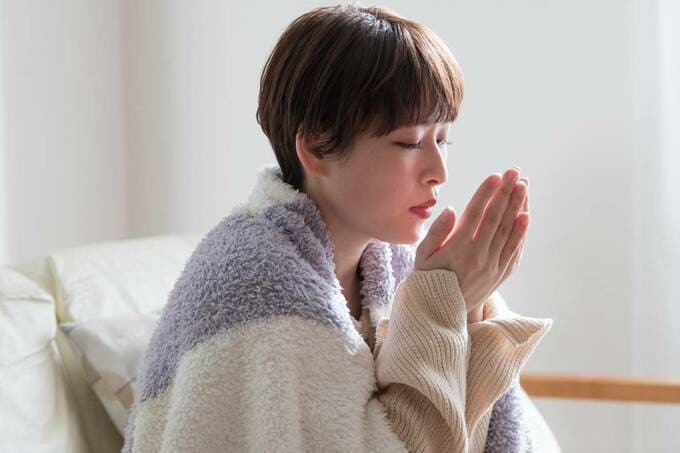 手をあたためる女性