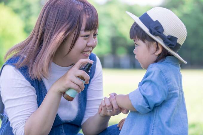 子どもにスプレーする女性