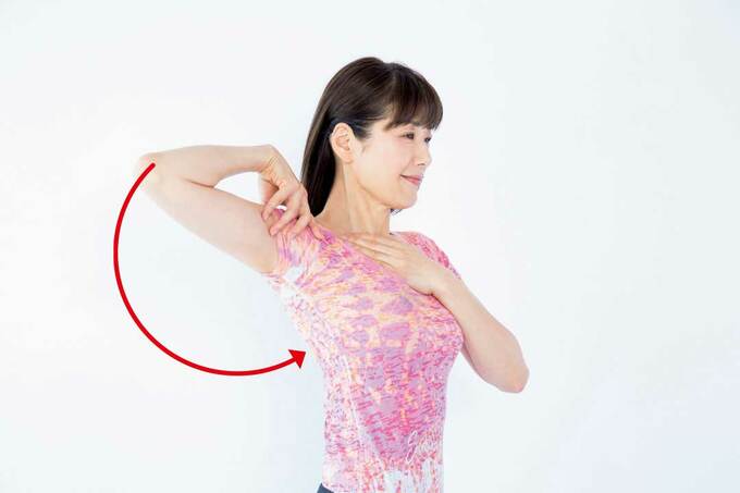 右手を右肩の上にのせ肩を前から後ろへ回す様子