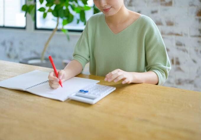 家計簿に書き込む女性