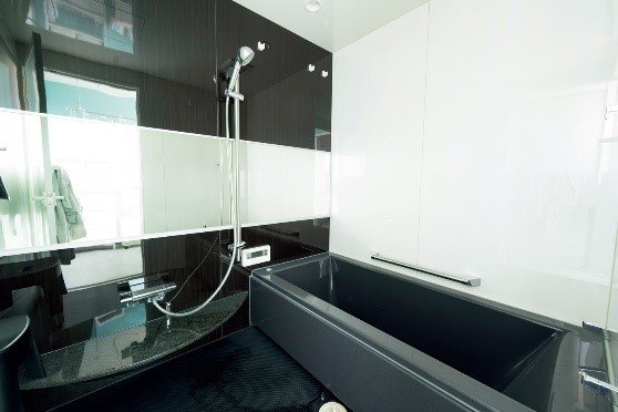 白い壁と黒い浴槽の浴室