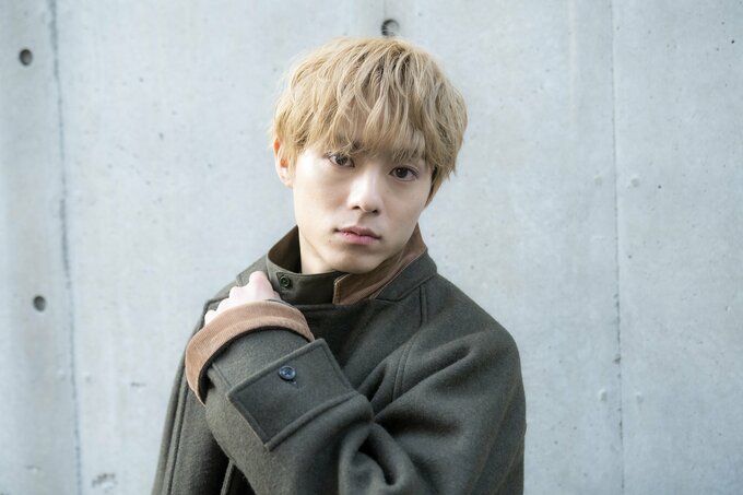 首もとに手をおく男性