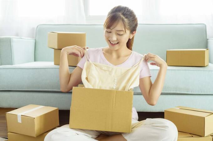 箱から服を取り出した女性