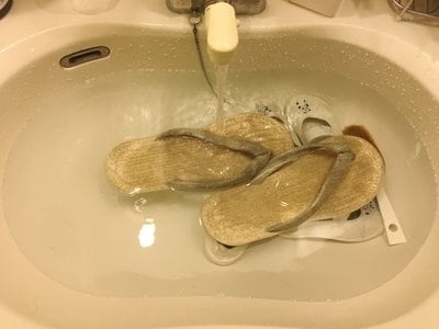水をためた洗面台にサンダル