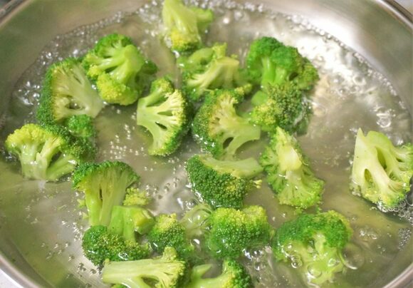 フライパンでお湯を沸騰させ、一口サイズにカットしたブロッコリーを入れます。