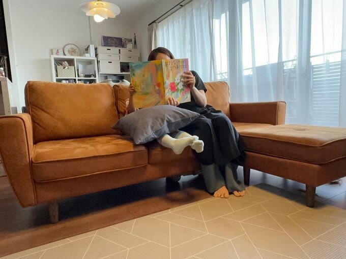 ソファで子どもと絵本を読む様子