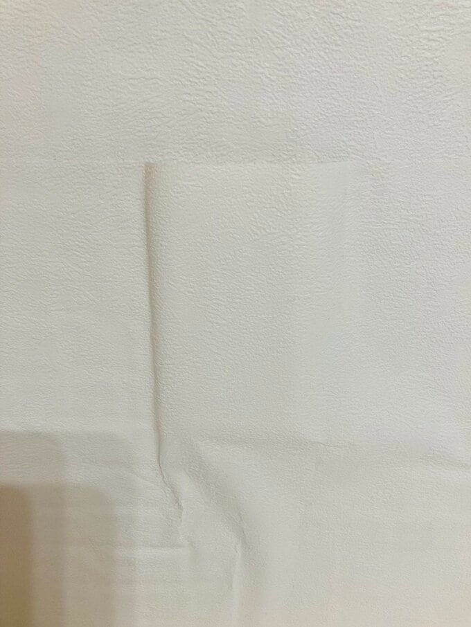 壁紙におおわれたコンセント