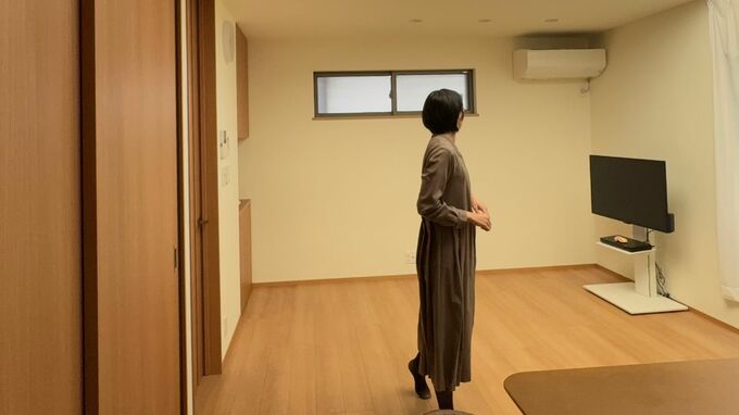 リビングで立つ女性の後ろ姿